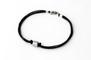 A black cord bracelet for men with a silver tube bead charm and a clasp closure.