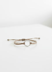 Bracelet with a silver circular clasp on a textured surface