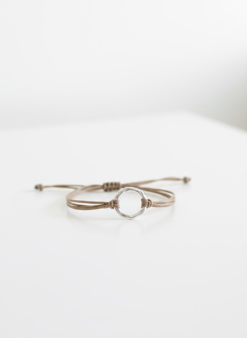 Bracelet with a silver circular clasp on a textured surface