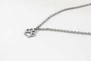 A stainless steel chain necklace with a silver-tone stainless steel paw pendant, displayed against a white background.