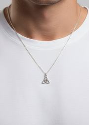 Silver necklace with a Trinity knot pendant on a white shirt