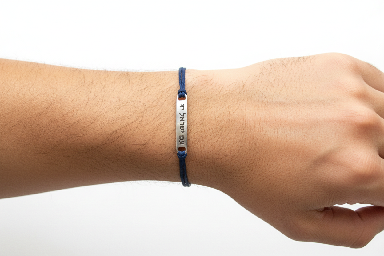Navy blue bracelet with engraved text on a wrist against a white background