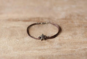 Bracelet with a starfish charm on a wooden surface