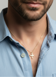Man wearing dragonfly necklace a light blue shirt with a neutral background