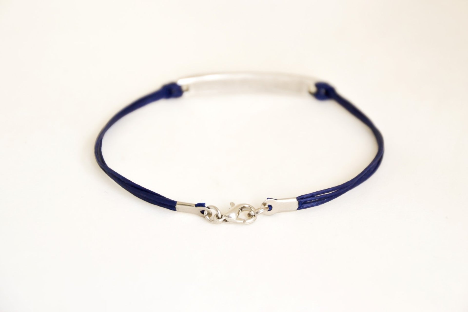 Navy blue bracelet with a silver clasp on a white background