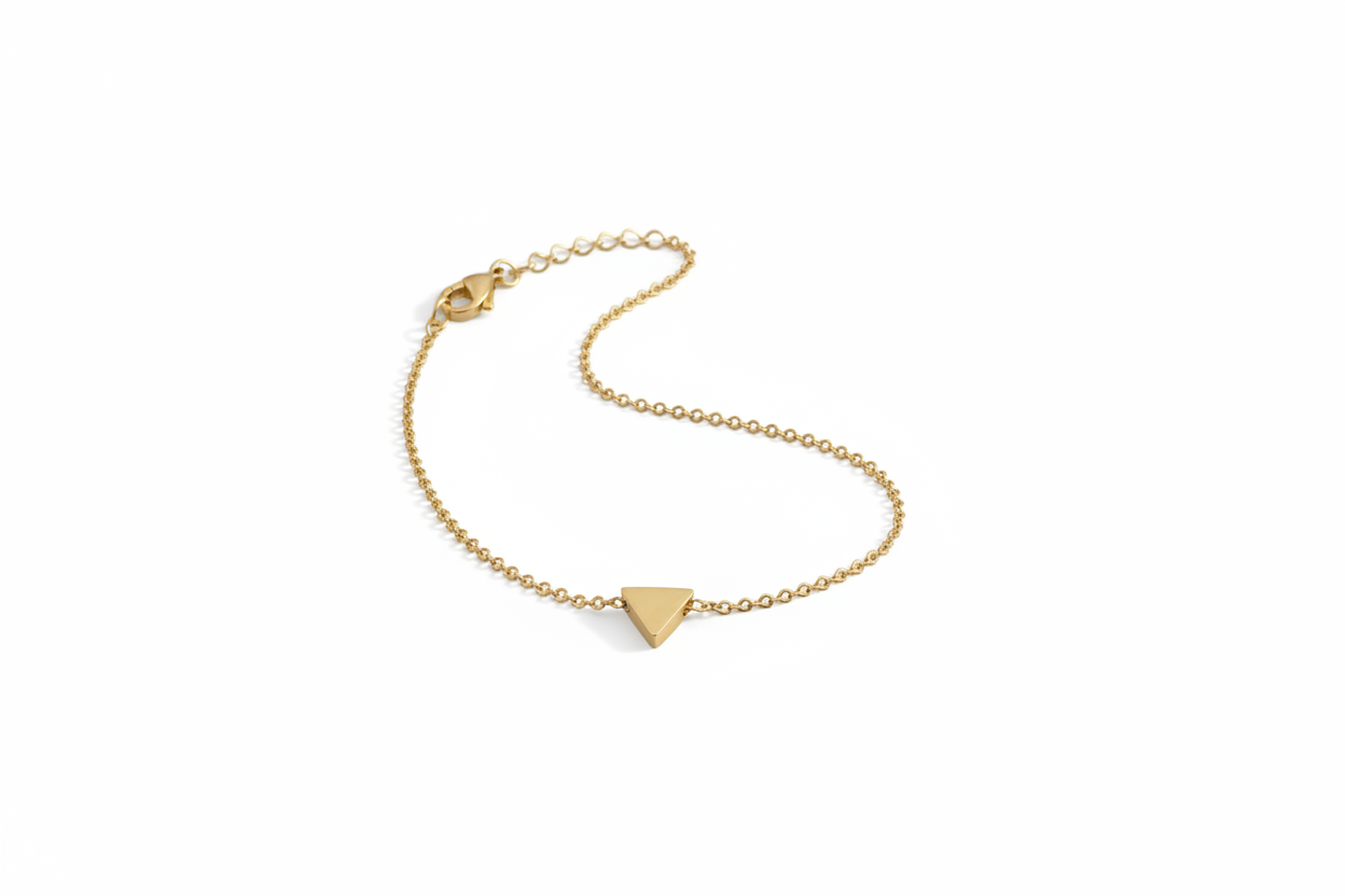 Gold bracelet with a triangle charm on a light gray background