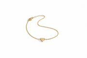 Gold bracelet with a triangle charm on a light gray background