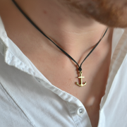 Bronze anchor necklace on a person wearing a white shirt