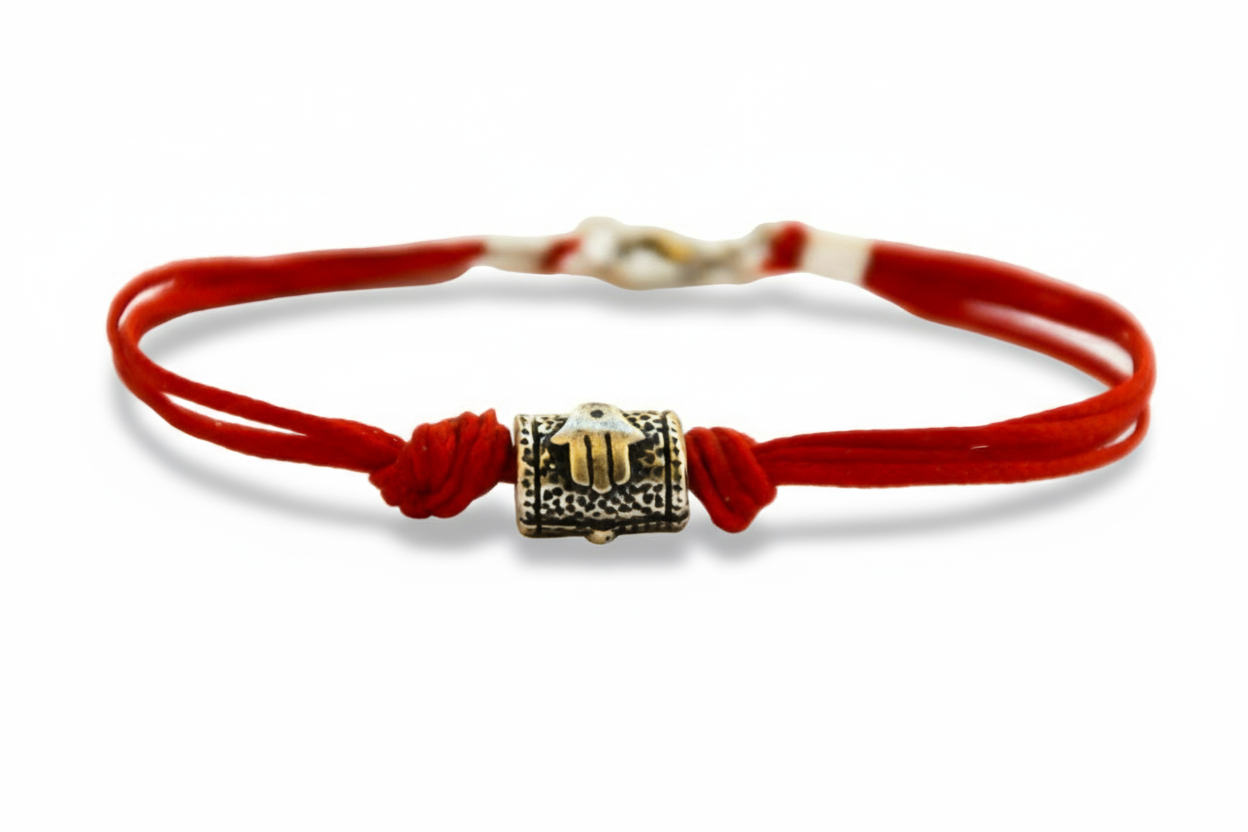 Red string bracelet hamsa bead with a silver clasp on a white background