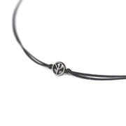 Black leather cord necklace with a silver peace symbol charm on a white background