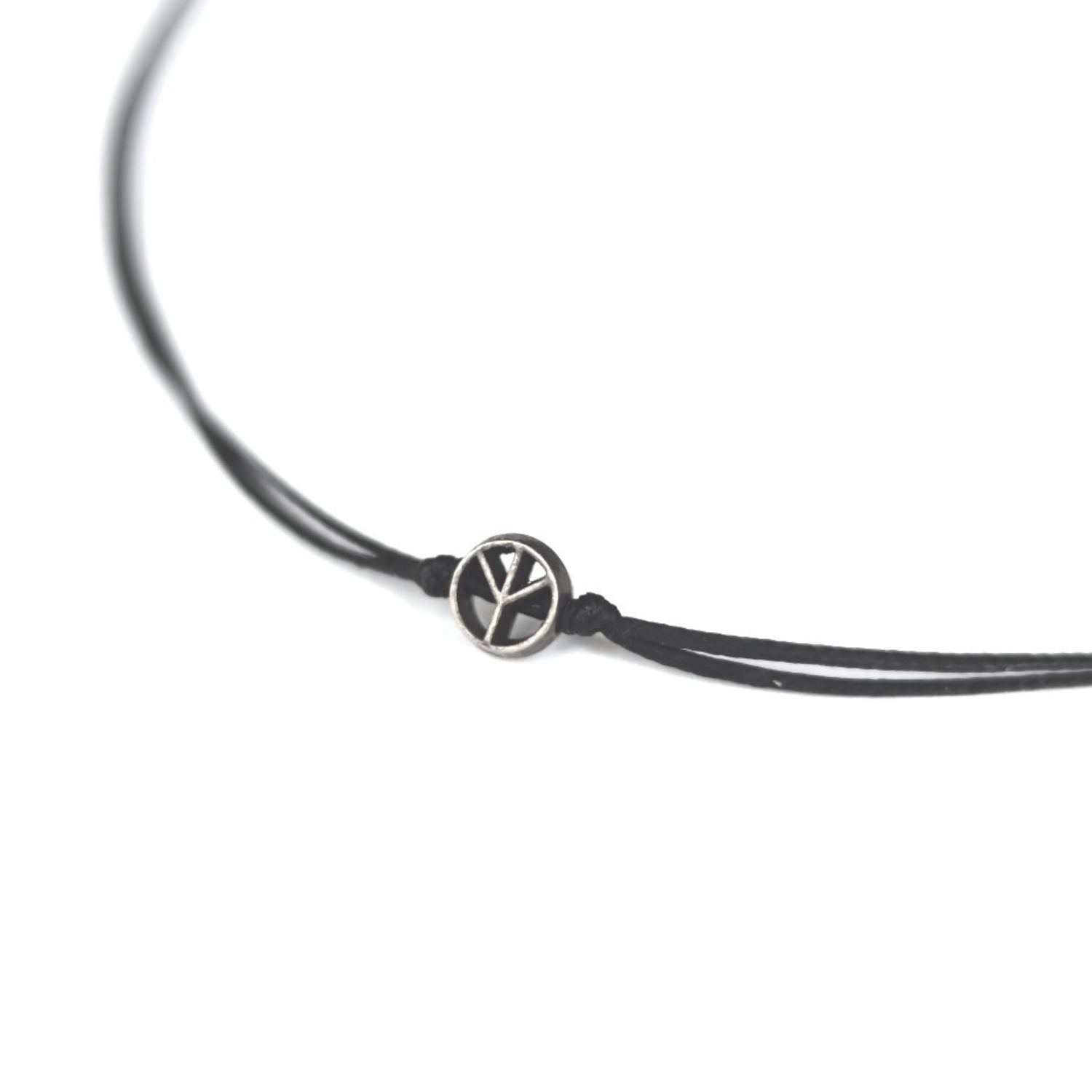 Black leather cord necklace with a silver peace symbol charm on a white background