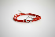 Red hamsa bracelet with a silver clasp on a light gray background