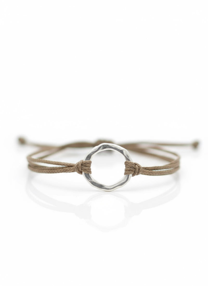 Bracelet with a silver circular clasp on a textured surface
