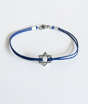 Blue bracelet with a silver Star of David charm on a white background